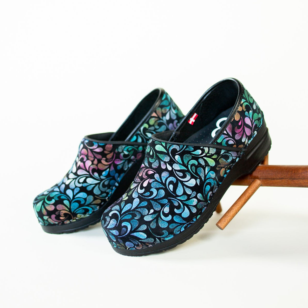 Multicolored blue clog with paisley print on white background.